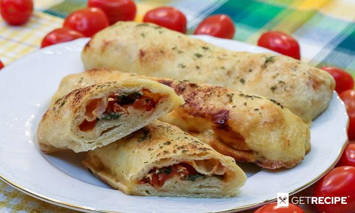 Photo of Закрытая пицца-палочка с моцареллой и помидорами.