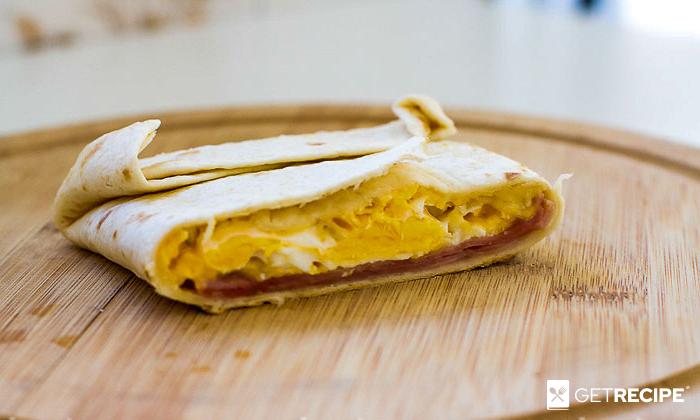 Photo of Горячий бутерброд из тортильи с яйцом, сыром и ветчиной.