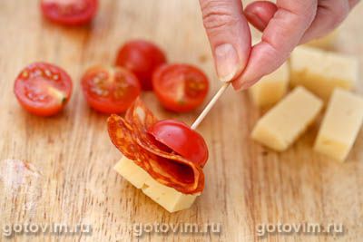 Закуска на шпажках из сыра с колбасой и помидорами черри.